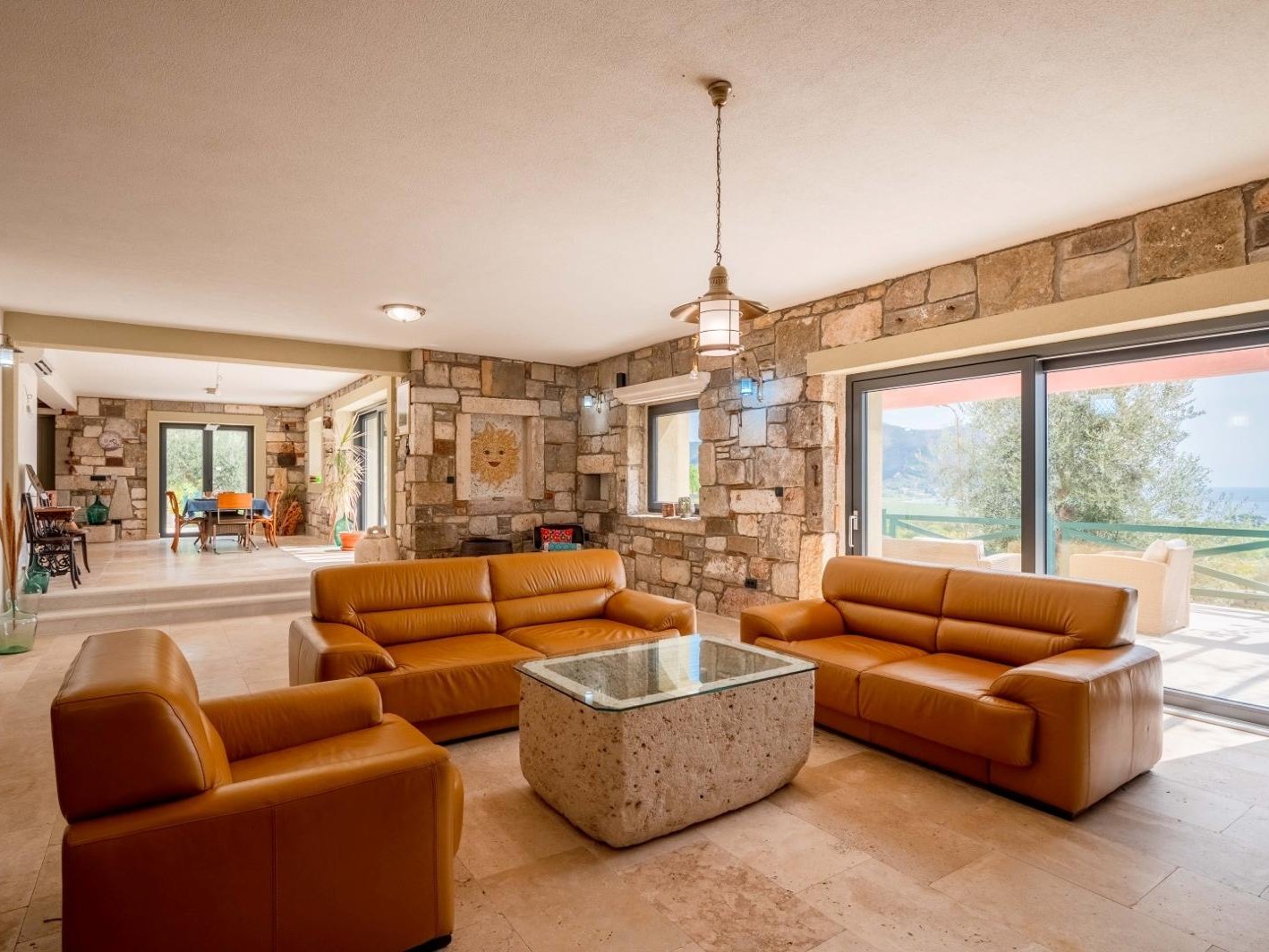 Salon avec murs en pierre et vue sur la mer à Paštrovići Stone Retreat
